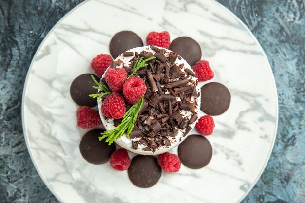 Top view cheesecake with chocolate on white oval plate on grey surface food photo