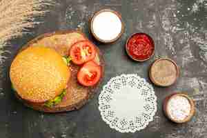 Free photo top view cheesy meat burger with seasonings on the dark desk bun sandwich meat fries