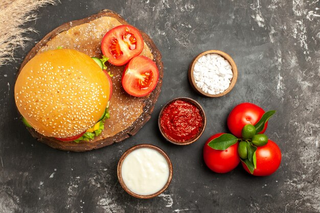 Top view cheesy meat burger with seasonings on dark surface bun fries meat sandwich