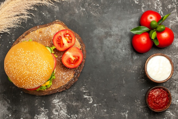 Free photo top view cheesy meat burger with tomatoes on dark floor bun fries meat sandwich