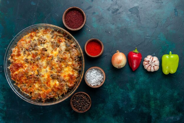 Вид сверху сырной мясной еды со свежими овощами и приправами на темно-синем письменном столе мясная еда овощной ужин