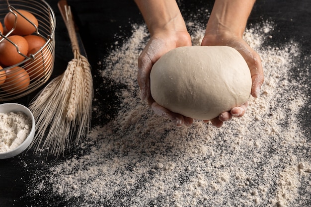 Free photo top view of chef holding bread dough