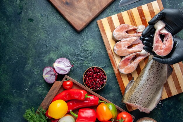 Top view chef holding raw fish slices on kitchen table