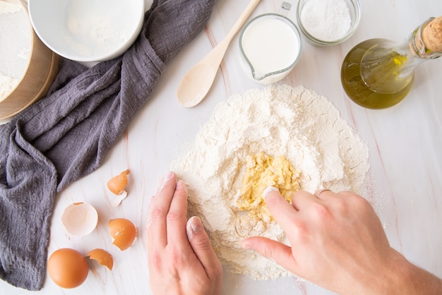 Top view chef mixing eggs with flour