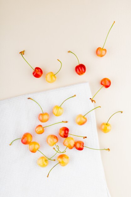 Top view of cherries on white cloth and white surface