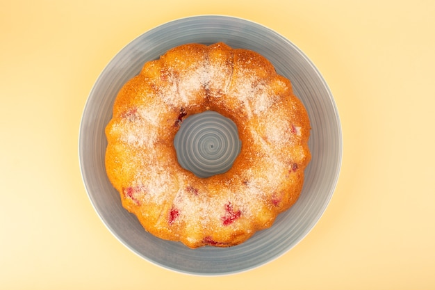 Foto gratuita una torta di ciliegie con vista dall'alto si è formata all'interno della lastra grigia sullo zucchero giallo del biscotto della torta dello scrittorio