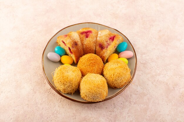 A top view cherry cake slices with candies on the pink desk cake biscuit sugar sweet