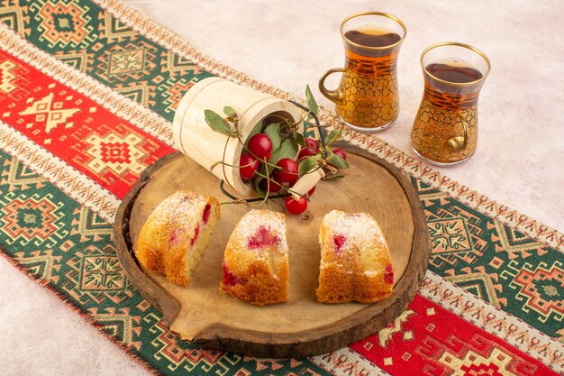 A top view cherry cake slices with tea on the pink desk cake biscuit sugar sweet