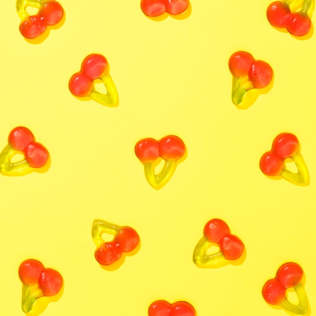 Top view cherry candies on yellow background