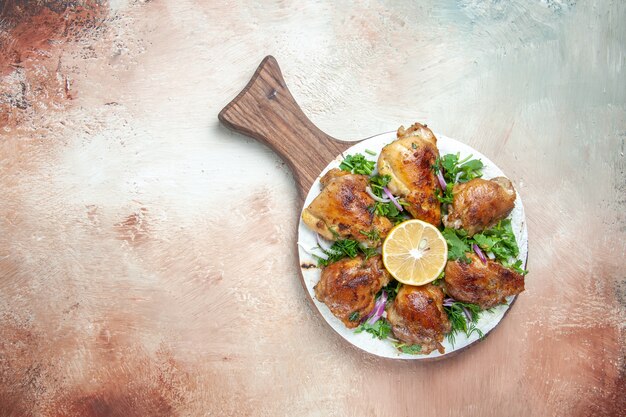 Top view of chicken an appetizing chicken with lemon herbs onion on the cutting board