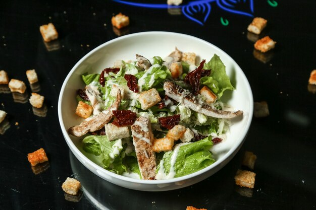 Top view chicken caesar salad with croutons on the table