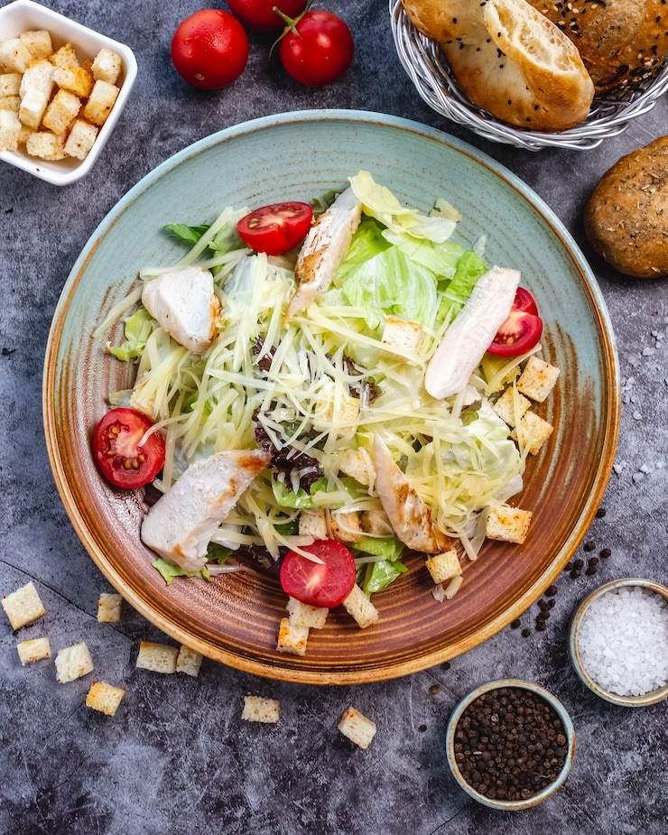 Бесплатный Фотография вид сверху салат цезарь с курицей с салатом из помидоров черри с начинкой из хлеба с помидорами и пармезаном