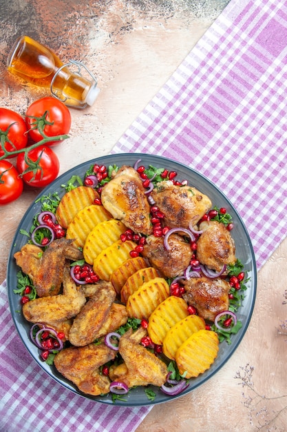 식탁보에 pedicels와 닭 닭 날개 감자 기름 토마토의 상위 뷰
