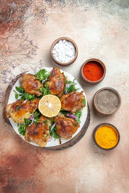 Vista dall'alto di pollo pollo con erbe aromatiche al limone sul tagliere spezie in ciotole