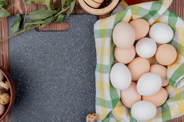 복사 공간 나무 배경에 잎 나무 그릇에 메 추 라 기 계란 체크 식탁보에 닭고기 달걀의 상위 뷰