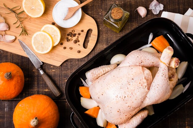 Вид сверху курицы в сковороде с ломтиками лимона на день благодарения