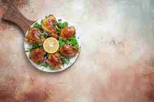Free photo top view of chicken pieces of chicken with herbs lemon onion on lavash on the board