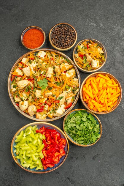 Бесплатное фото Вид сверху куриный салат с овощами и зеленью на темном столе диетический салат для здоровья