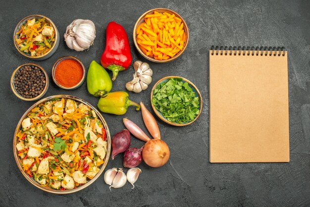 Вид сверху куриный салат с овощами на темном столе диетическое здоровое питание