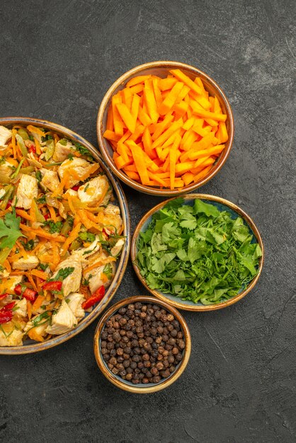 Вид сверху куриный салат с овощами и зеленью на темном столе диетический салат для здоровья