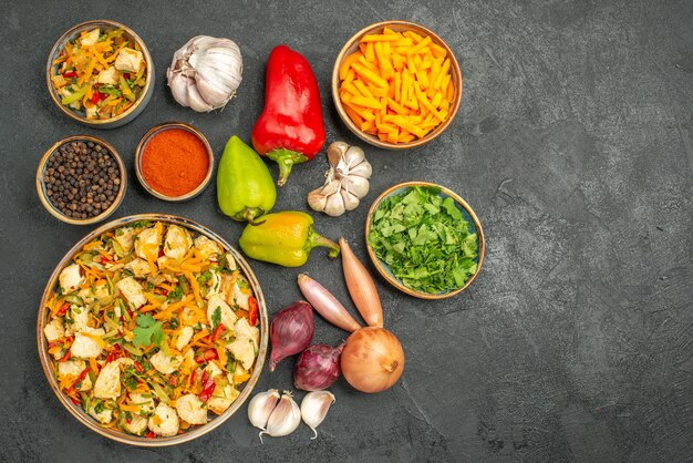 Вид сверху куриный салат с овощами и зеленью на темном столе для здоровья спелых