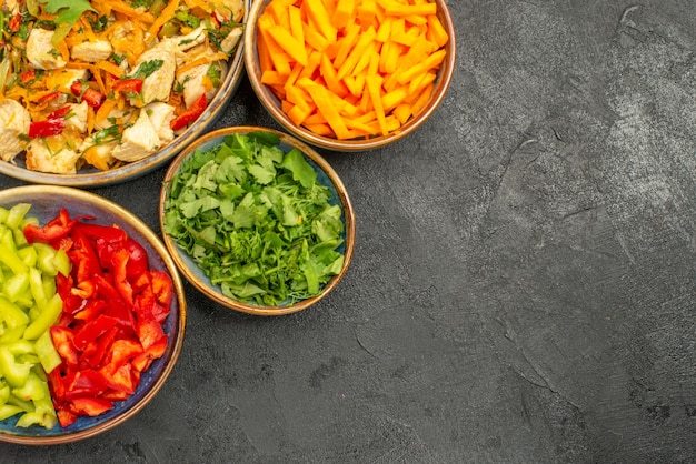 Top view chicken salad with vegetables and greens on dark table salad health