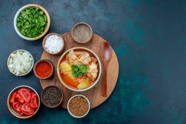 Free photo top view chicken soup along with seasonings oil greens and fresh vegetables on dark-blue desk soup meat food dinner meal