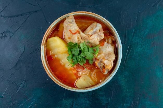 Top view chicken soup with chicken and greens inside on dark-blue desk soup meat food dinner chicken