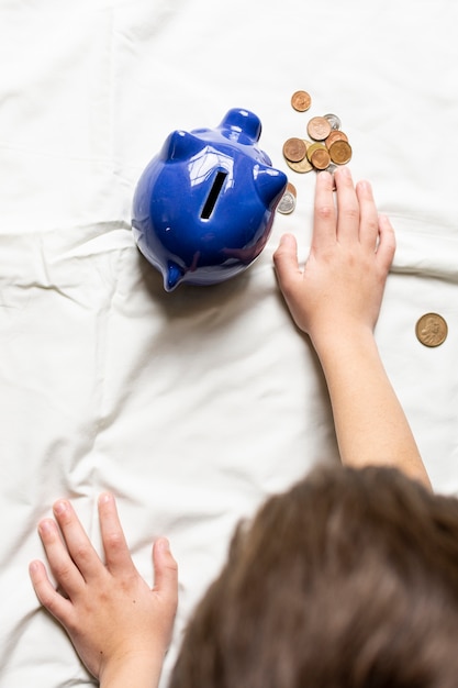 Free photo top view child counting his money from piggy bank