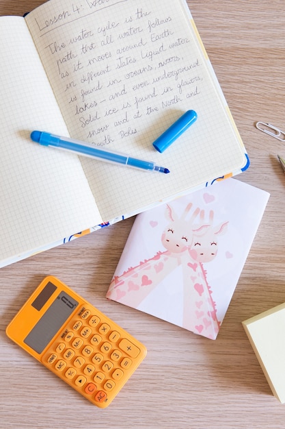 Top view of children's desk with notebook and calculator