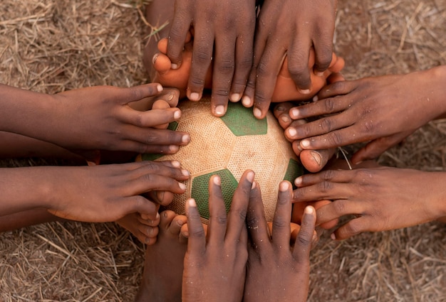 Top view childs feet around football ball