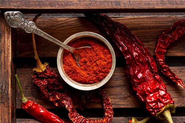 Top view of chili peppers on wooden tray with powder