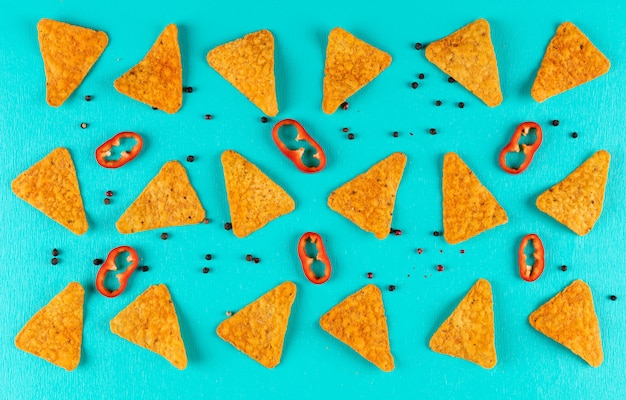 Top view chips pattern with pepper on blue horizontal
