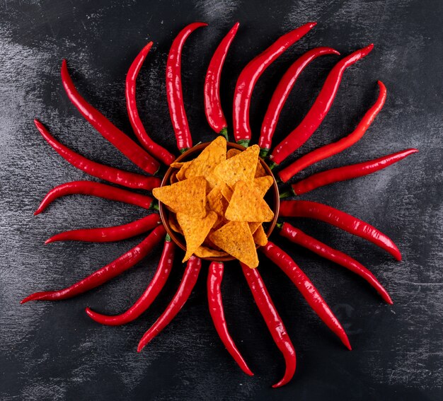 Top view chips with chilli in bowl on black stone  horizontal