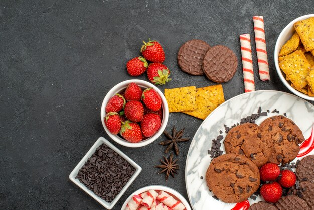 Вид сверху шоколадное печенье с конфетами и фруктами