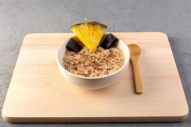 A top view choco dessert brown with pineapple slice choco bars on the cream wooden desk and grey