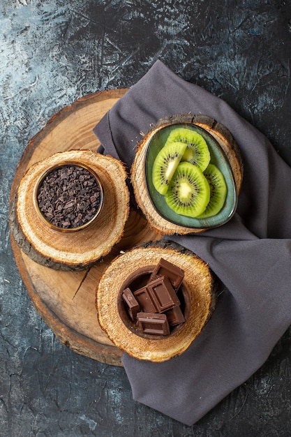 짙은 회색 표면 케이크 색상 조식 설탕 과일 디저트에 신선한 슬라이스 키위가 있는 탑 뷰 초콜릿 바