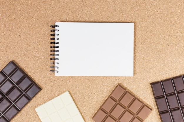 Top view chocolate bars with notebook