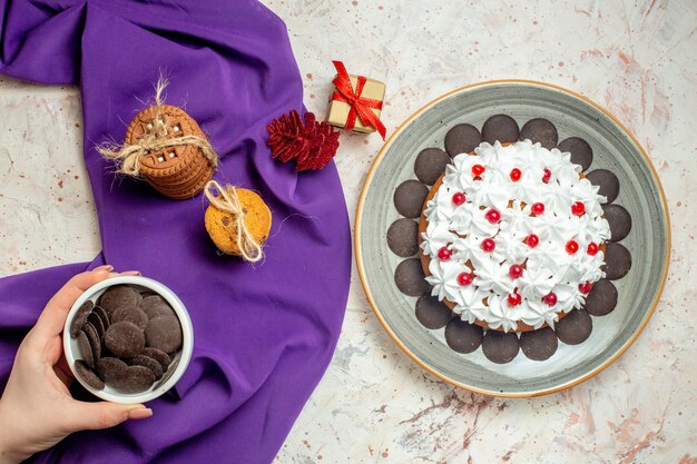 보라색 목도리에 밧줄로 묶인 여성 손 쿠키 그릇에 상위 뷰 초콜릿