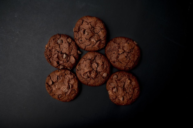 Top view of chocolate brownie cookies on a black background