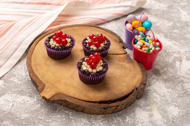 Top view chocolate brownies with cranberries on the wooden desk with candies cake biscuit sweet bake dough