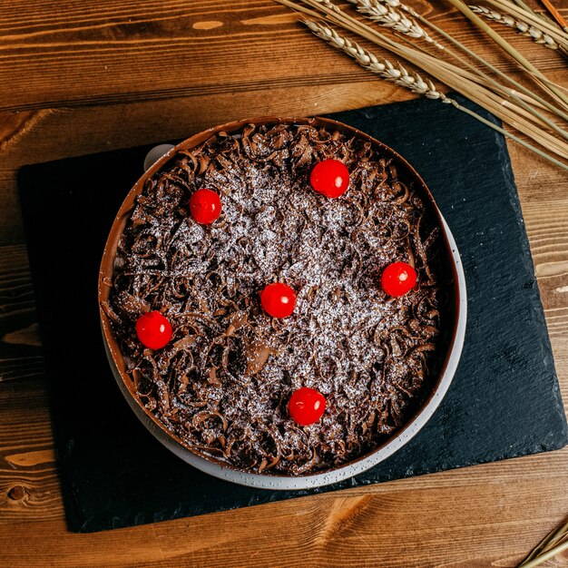 茶色のケーキの中のおいしいチェリーで飾られた上面チョコレートケーキ