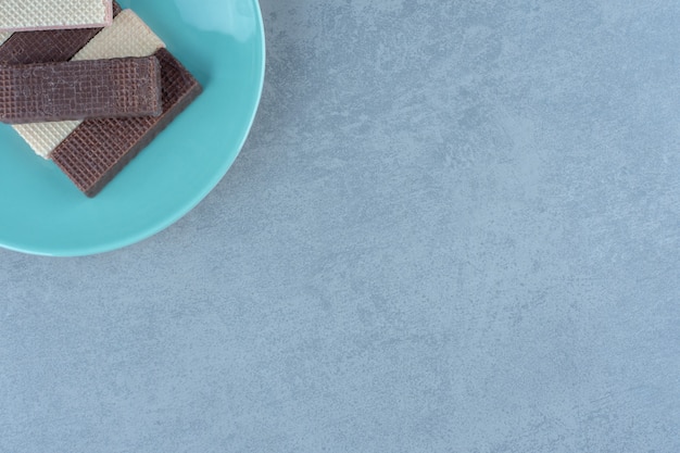 파란색 접시에 초콜릿과 카라멜 와플의 최고 전망.