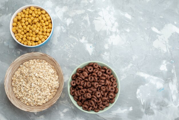 Top view chocolate cereals inside green plate on blue with yellow cereals