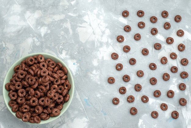 Free photo top view chocolate cereals inside green plate on blue