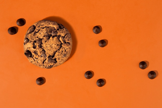 Biscotto con gocce di cioccolato vista dall'alto con sfondo arancione