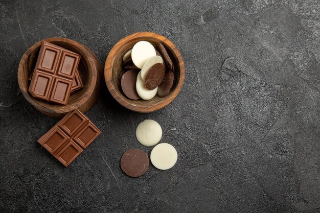 Top view chocolate chocolate in the wooden bowls on the table