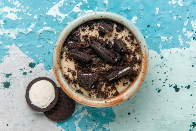 Top view chocolate cookie dessert with cream and cookies inside plate on blue background cake dessert sugar sweet color photo