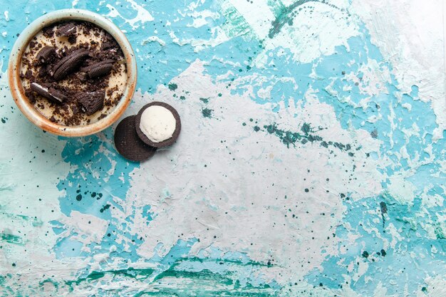 Top view chocolate cookie dessert with cream and cookies inside plate on light blue background cake dessert sugar sweet color photo