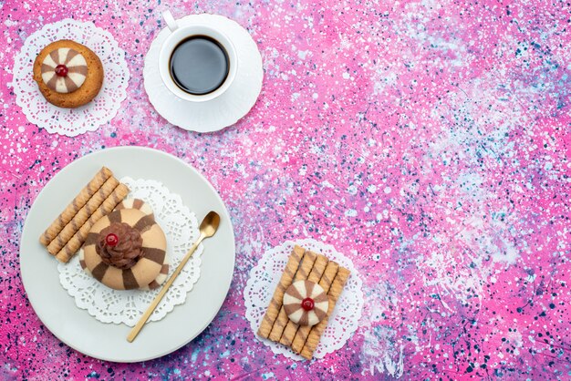 色付きの背景上にコーヒーのカップと平面図チョコレートクッキークッキー砂糖甘いビスケット焼き生地